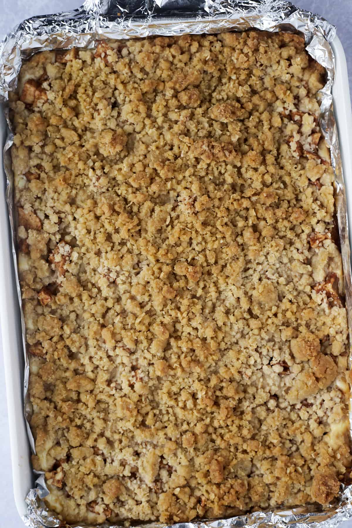 overhead image of caramel apple cheesecake bars in a baking dish
