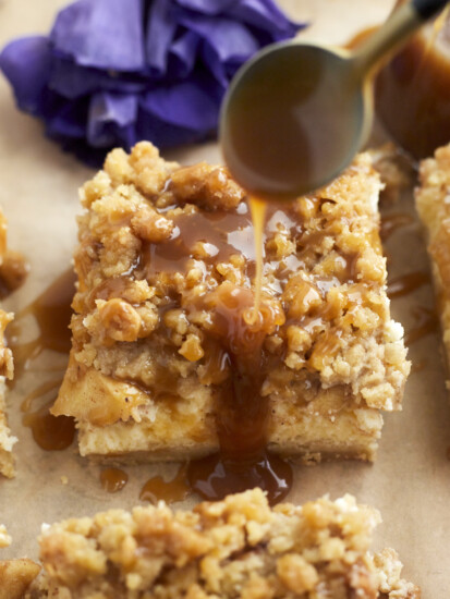 caramel being drizzled over caramel cheesecake bars