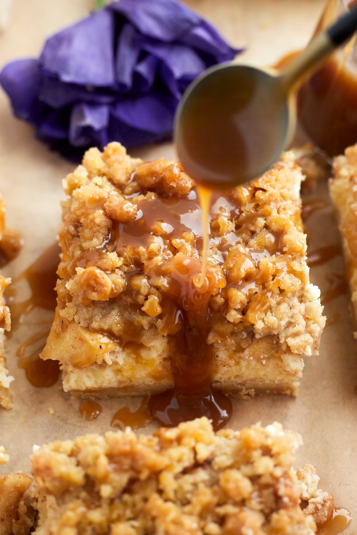 caramel being drizzled over a caramel apple cheesecake bar