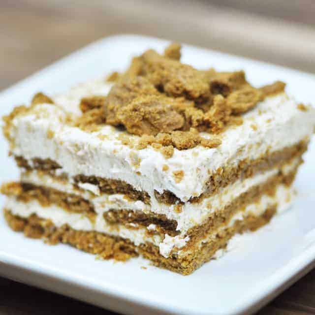 A large square of Biscoff cake on a square plate.