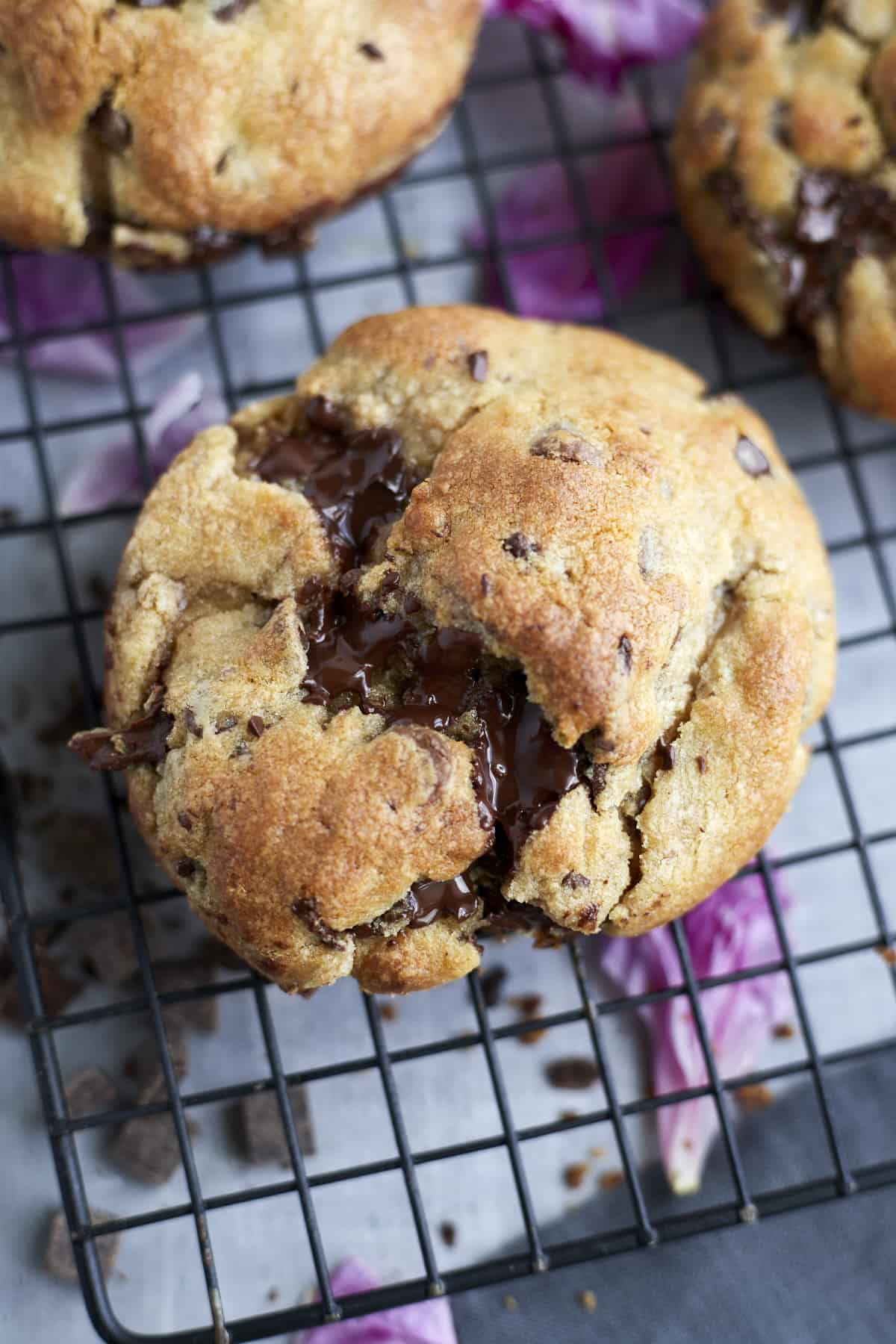 large cookie broken in half on a cooling rack