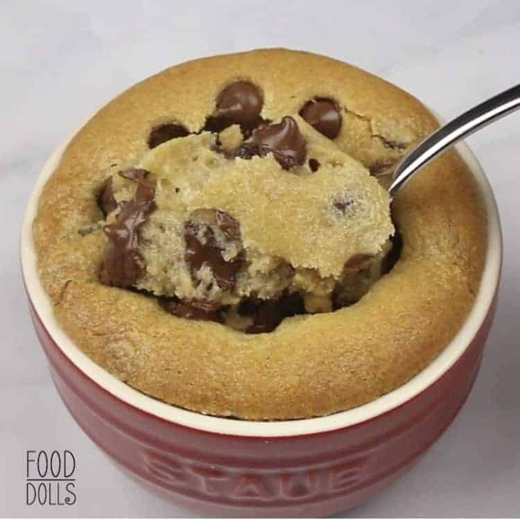 A spoon scooping up a bite from the center of a Deep Dish Chocolate Chip Cookie stuffed with marshmallows.