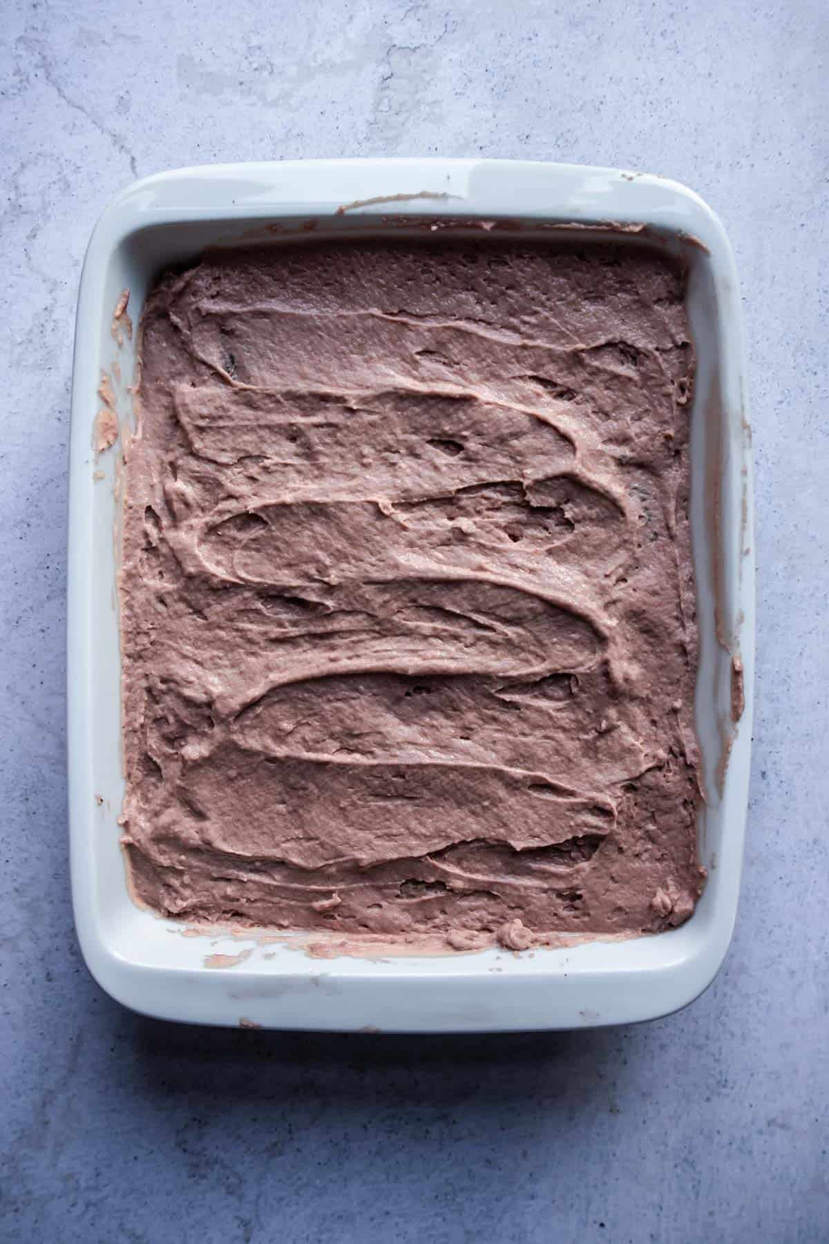 a mocha chocolate whipped cream layer in a baking dish for an icebox cake