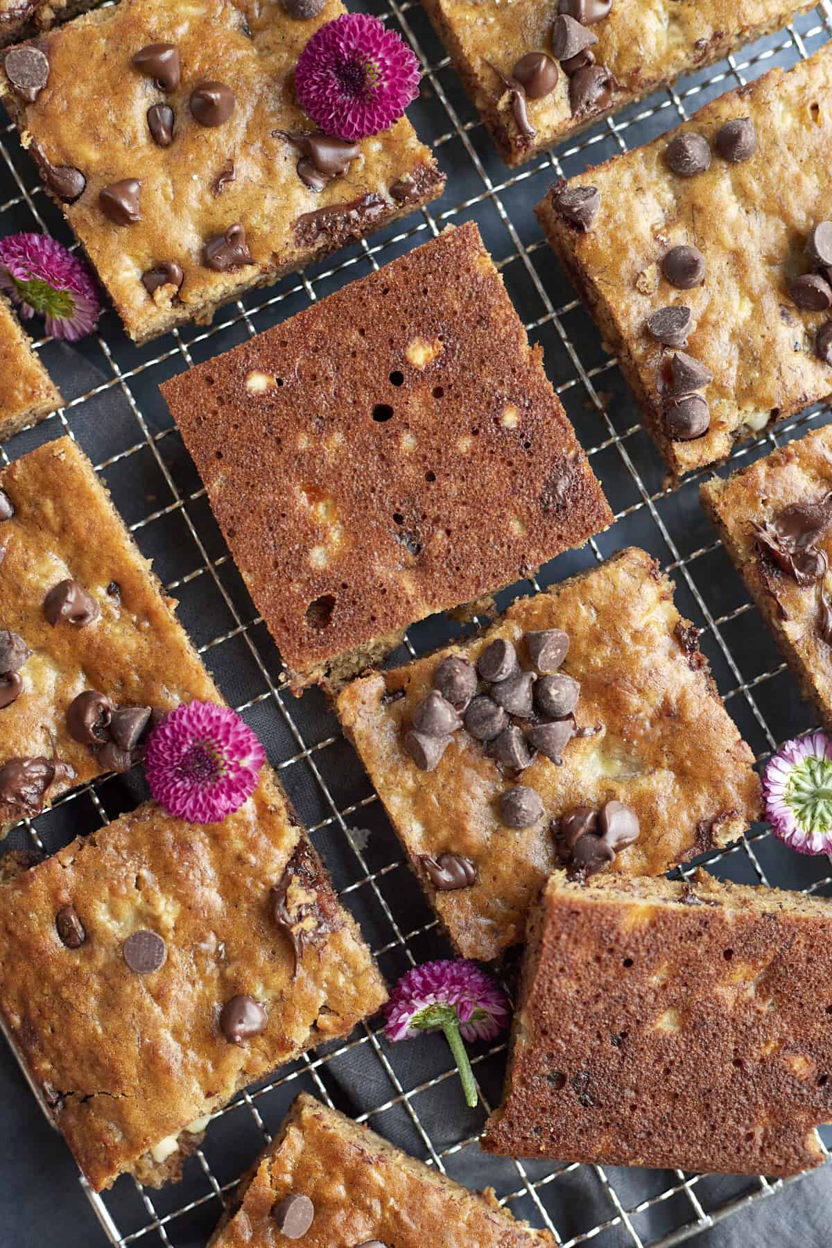 banana bread cut into squares and placed on a cooling rack. A few arranged upside down to see the bottom.