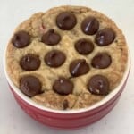 a bowl of Nutella stuffed cookie cake topped with chocolate chips