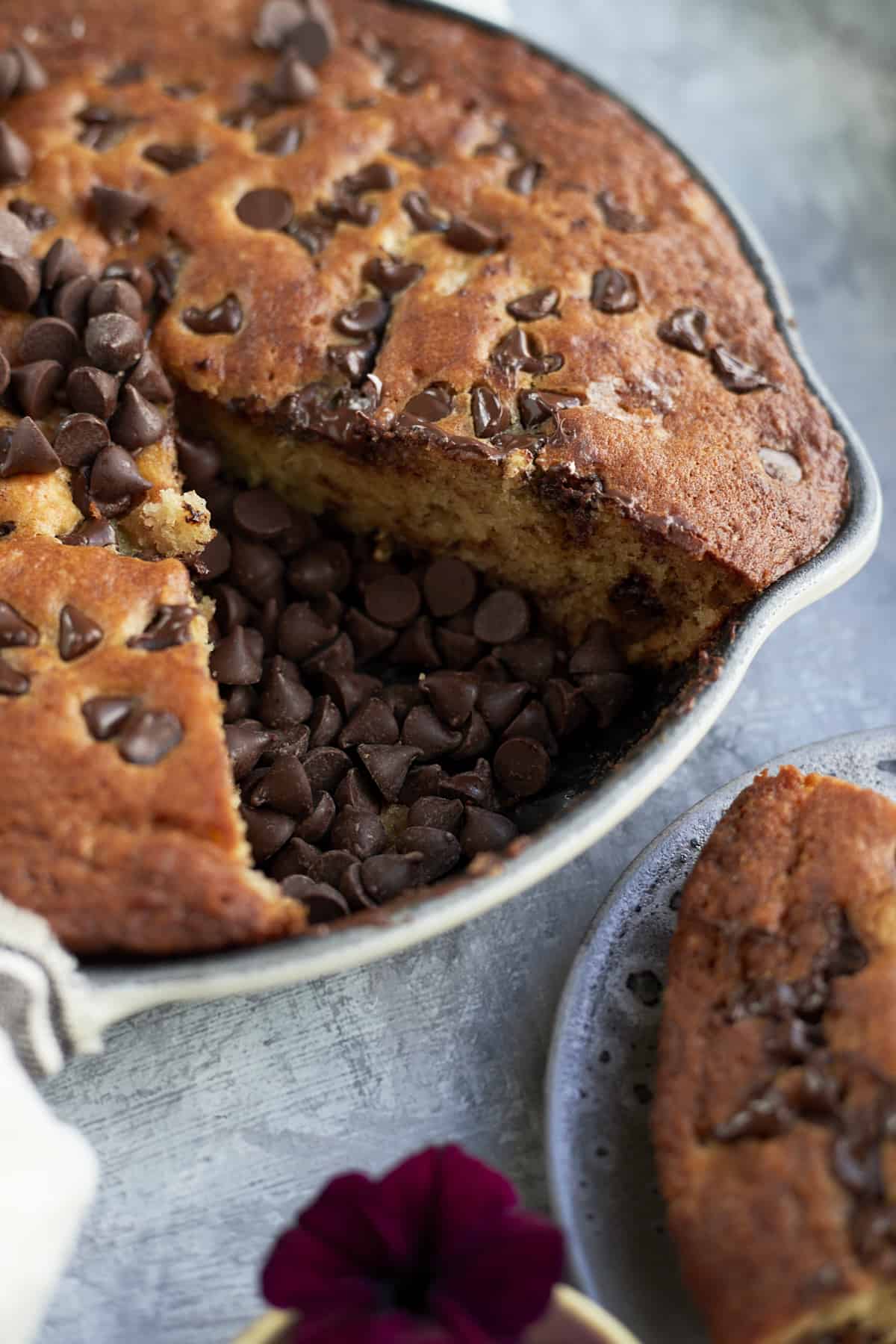 close up of banana bread with chocolate chips with a slice removed and on a plate