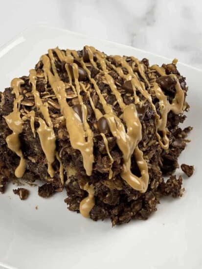 A serving of chocolate peanut butter oatmeal bake topped with a drizzle of peanut butter.