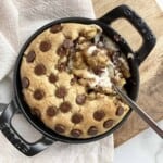 cheesecake stuffed chocolate chip cookie skillet with a spoon digging in