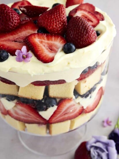 Side view of a summer berry trifle with strawberries and blueberries.