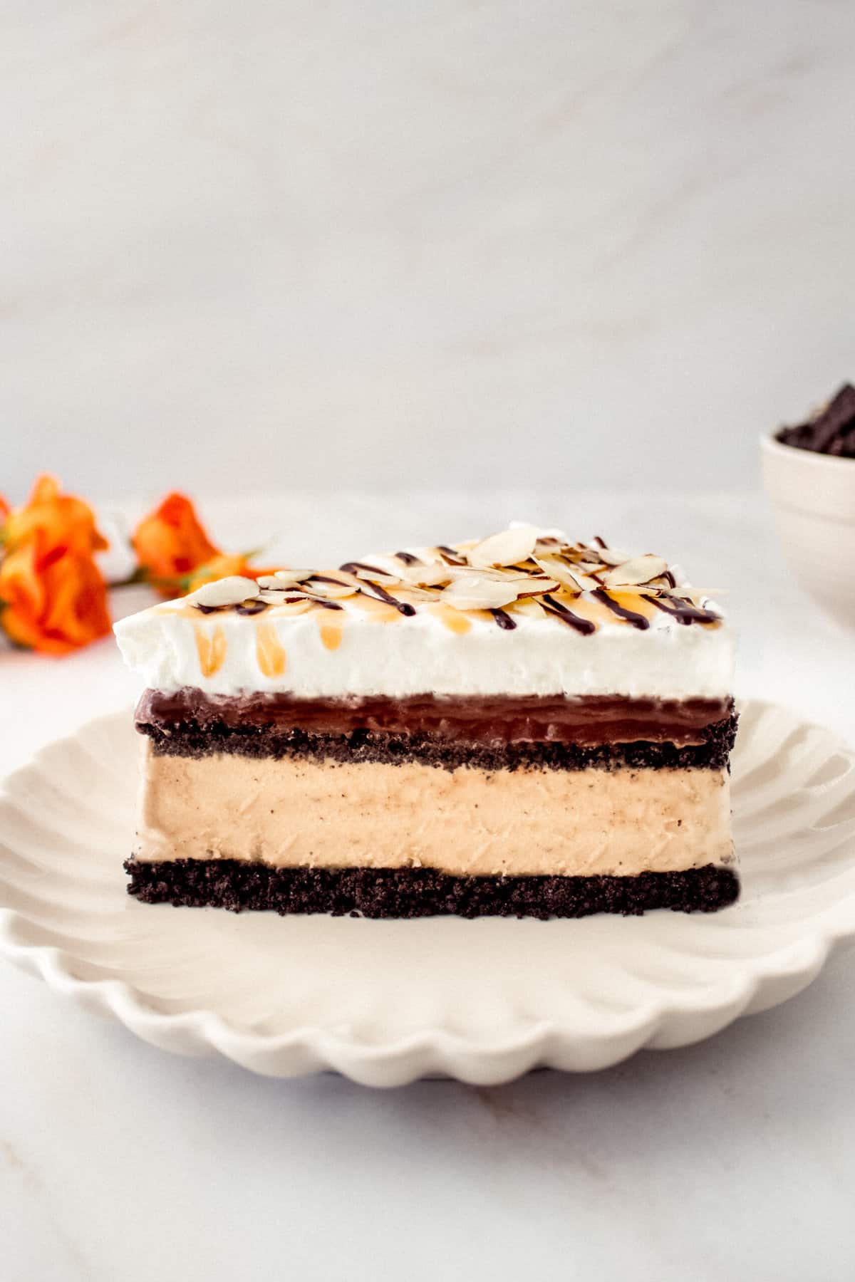 a side view of a slice of Billy Miner ice cream pie showing the layers of chocolate crust, coffee ice cream, fudge, and whipped topping