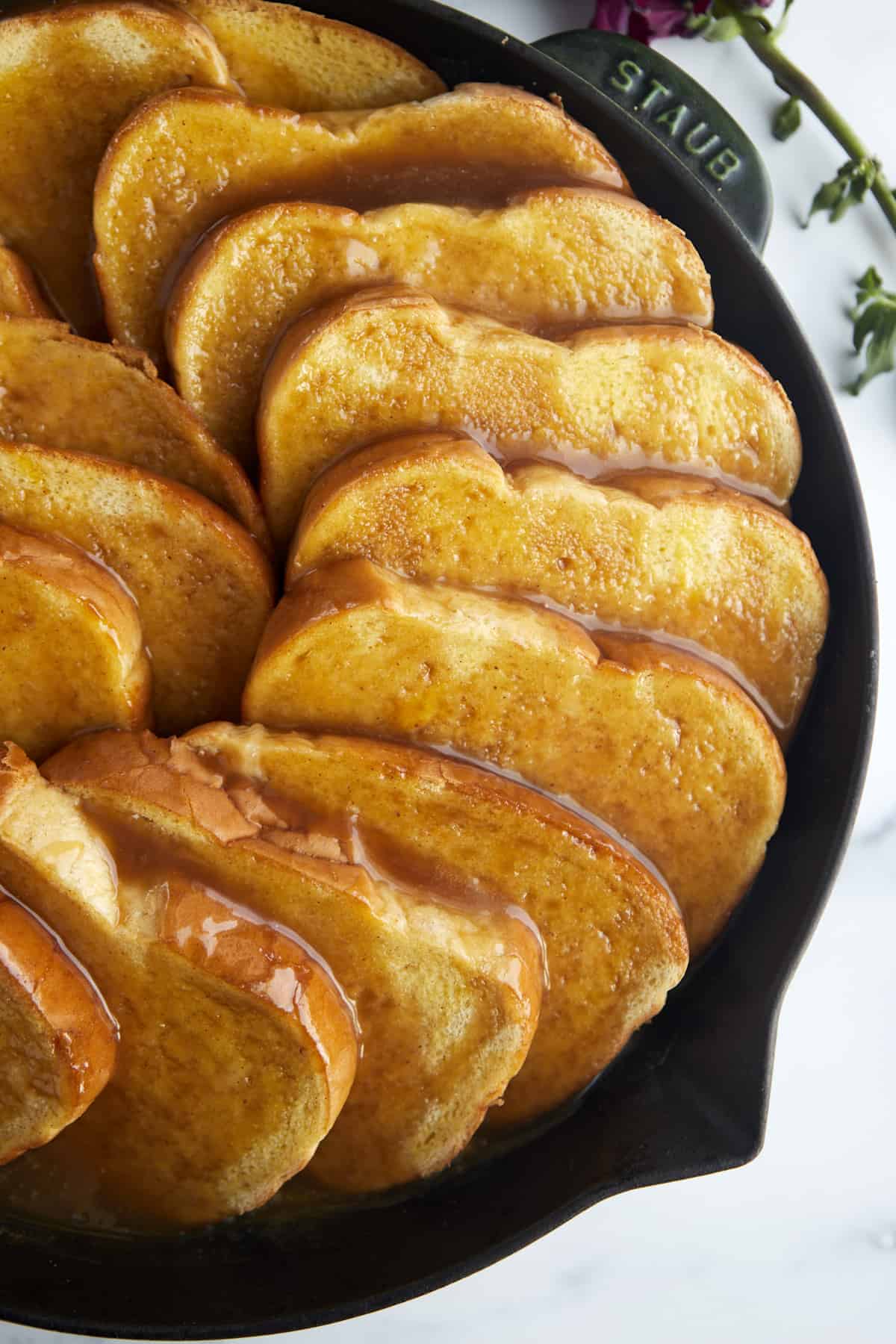 unbaked french toast in a skillet topped with caramel sauce