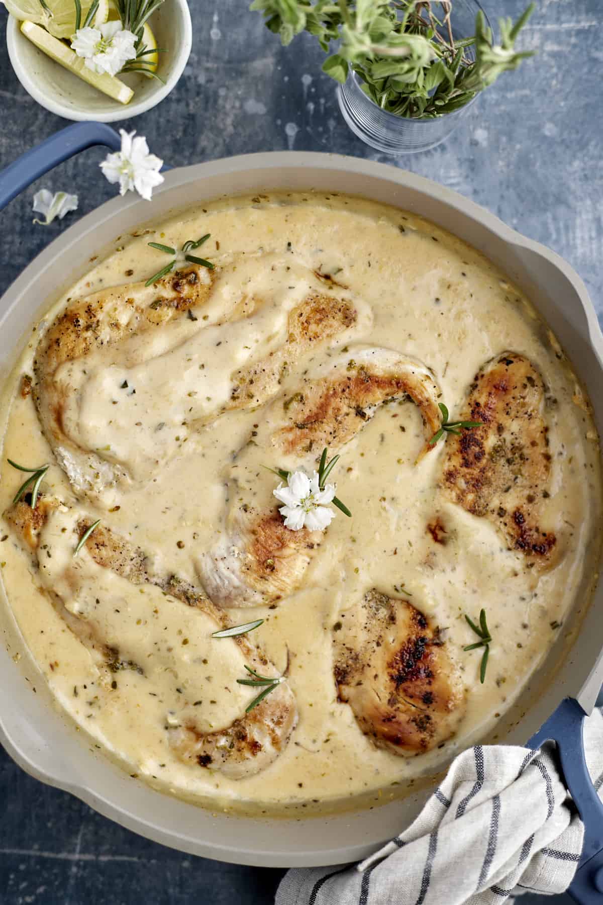 overhead image of creamy herb chicken in a white pot.