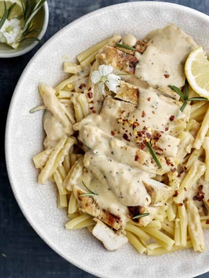 a bowl of creamy herb chicken over pasta.
