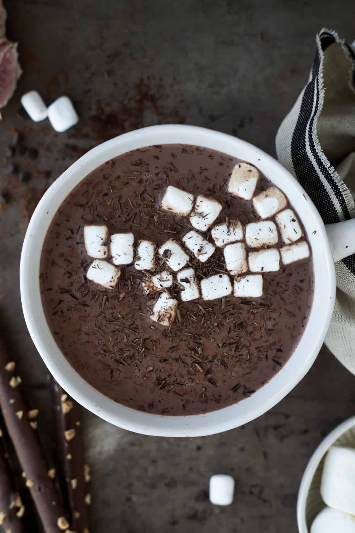 A mug of slow cooker hot chocolate with espresso topped with chocolate shavings and marshmallows.