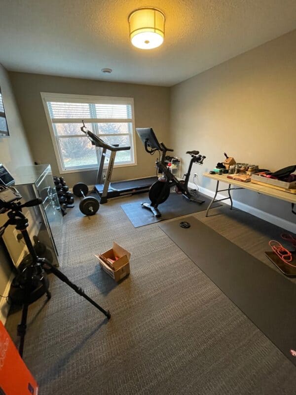 picture of a dark room with white walls, cameras, and workout equipment