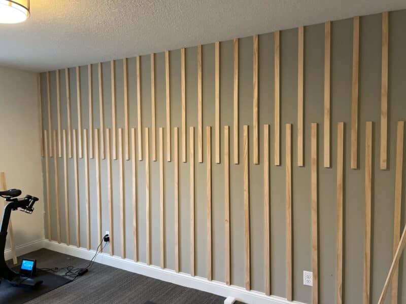 a grey wall with wood pieces stapled on