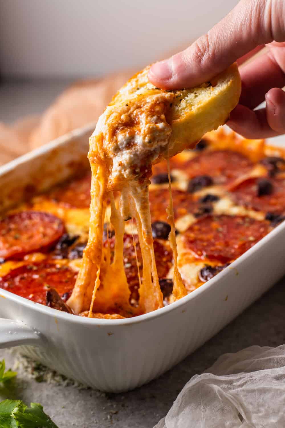 cheese crostini being dipped into pizza dip.