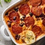 a cheese crostini on top of a dish of pizza casserole