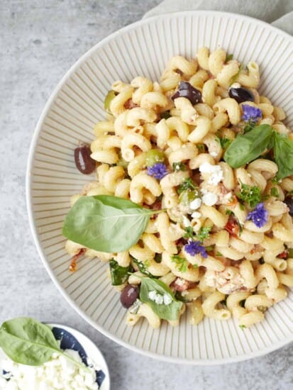 a white bowl full of tomato and feta pasta