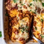 a baked lasagna roll being lifted up with a serving spoon