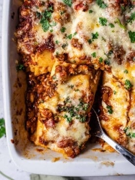 a baked lasagna roll being lifted up with a serving spoon