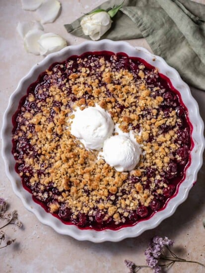 overhead image of a cherry crisp topped with two scoops of vanilla ice cream