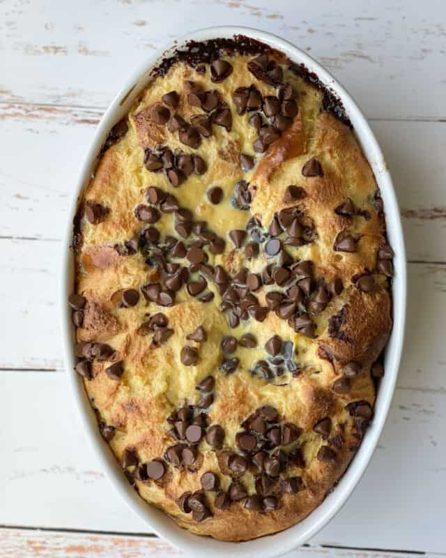 overhead image of baked tres leches bread pudding topped with chocolate chips