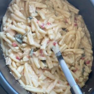 Crack Chicken Pasta in an Instant Pot being stirred with a wooden spoon