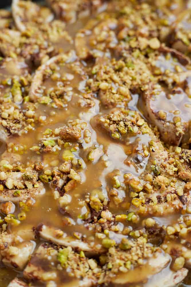 close up of baklava cinnamon rolls with caramel and pistachios.