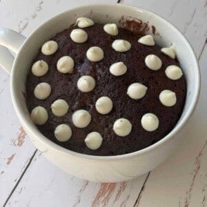 A chocolate mug cake topped with white chocolate chips.