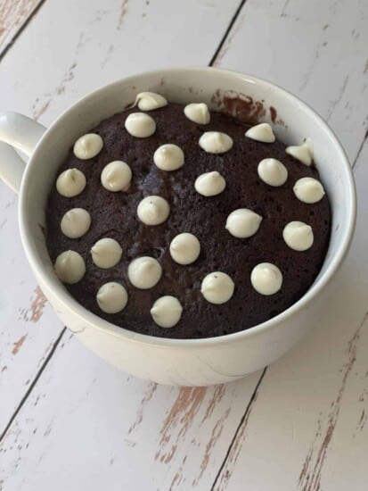 A chocolate mug cake topped with white chocolate chips.