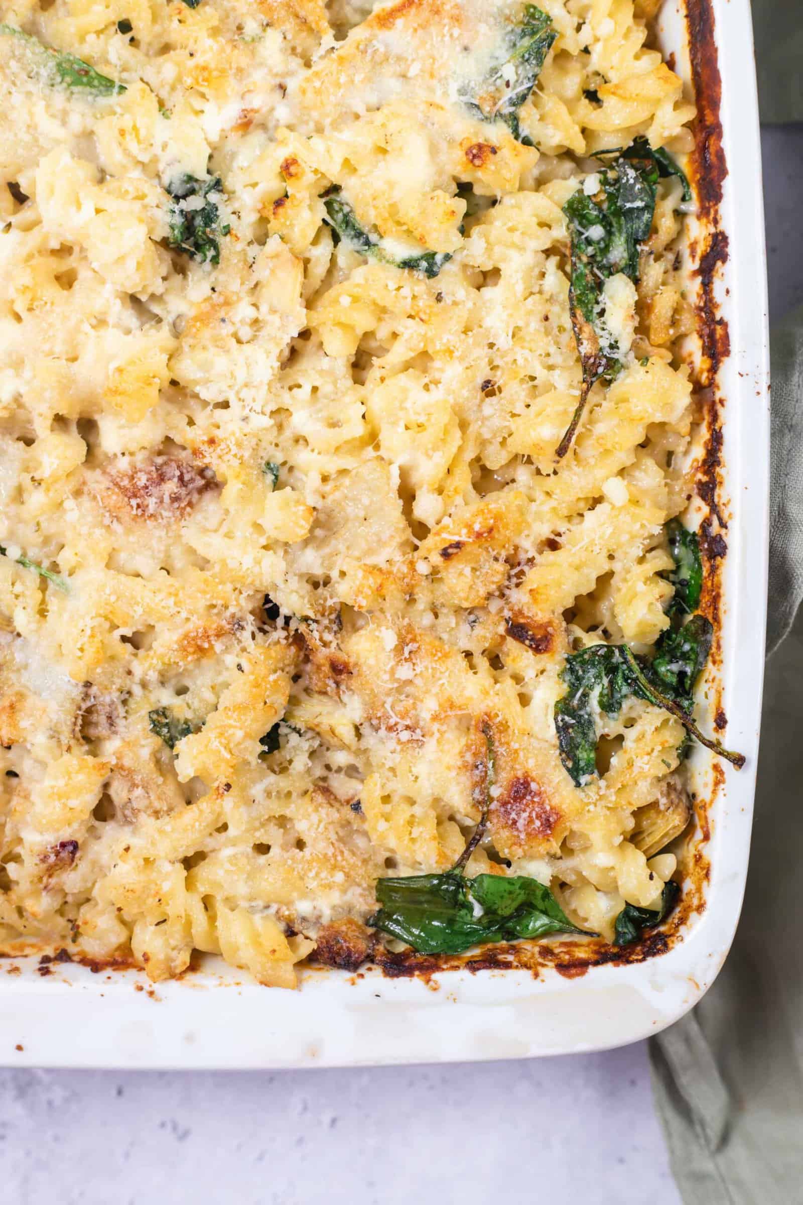 spinach and artichoke pasta bake in a white dish