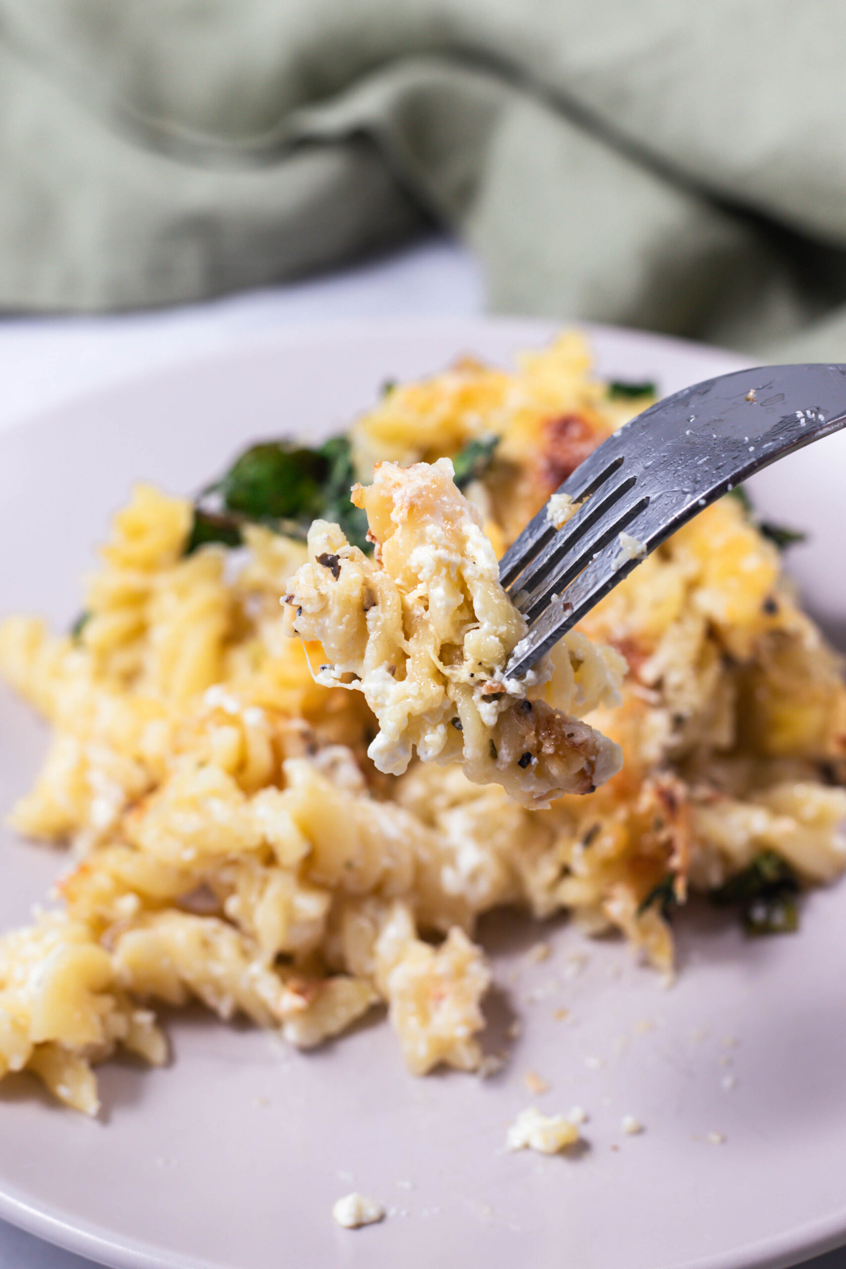 a fork full of spinach and artichoke pasta bake 