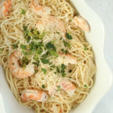 overhead image of baked garlic shrimp scampi with spaghetti noodles, shrimp, and Parmesan cheese
