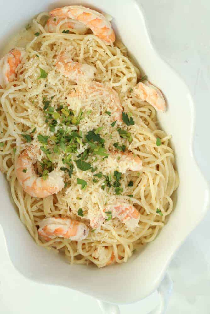 overhead image of baked garlic shrimp scampi with spaghetti noodles, shrimp, and Parmesan cheese