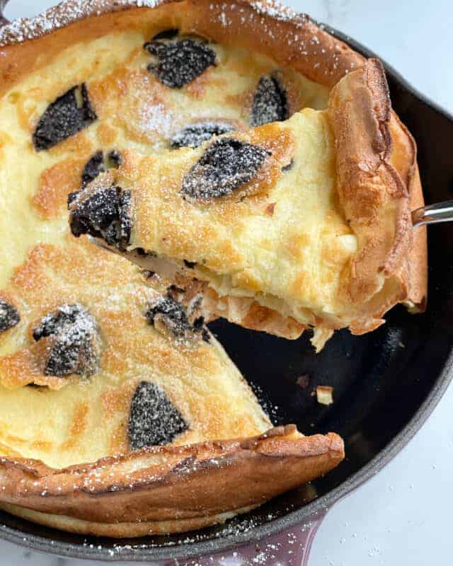 Oreo dutch baby pancake with a slice being lifted up.