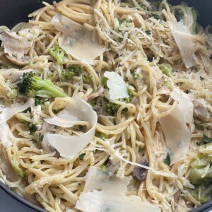 one pot pasta primavera with onions, mushrooms, and broccoli topped with shaved Parmesan cheese