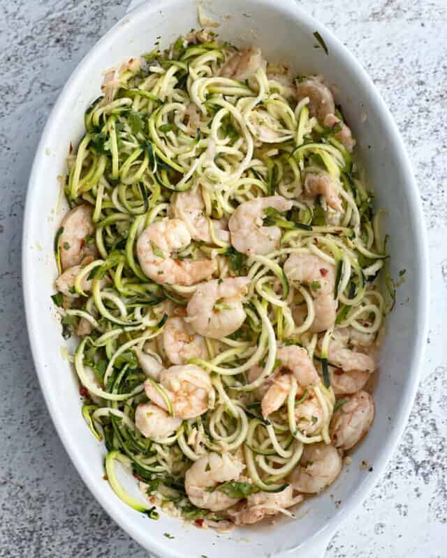 healthy shrimp scampi with zucchini noodles in a white oval baking dish
