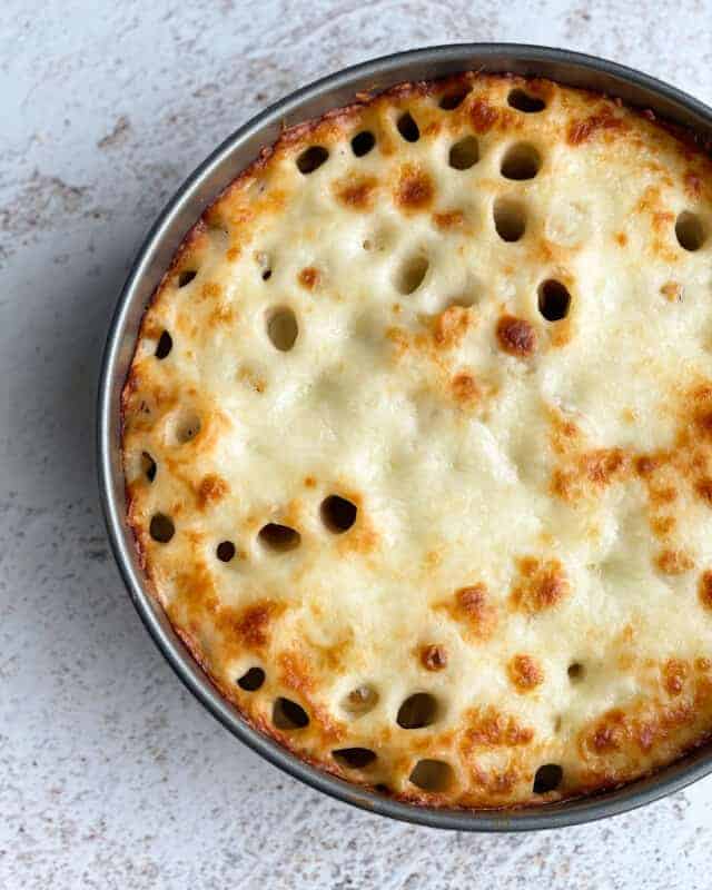 Overhead image of a honeycomb pasta cake in a circular dish.