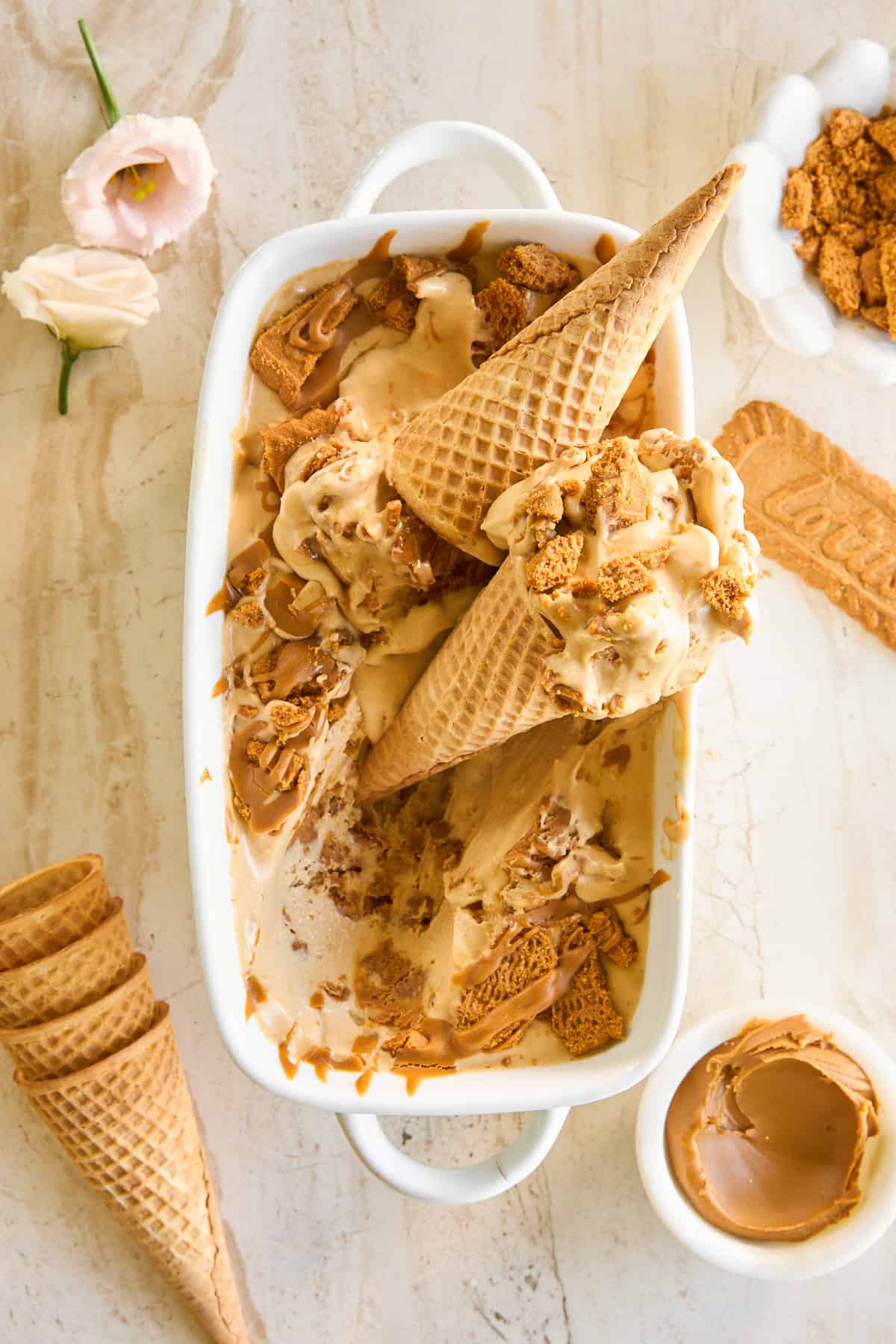 A dish of no-churn Biscoff ice cream with ice cream cones on top.