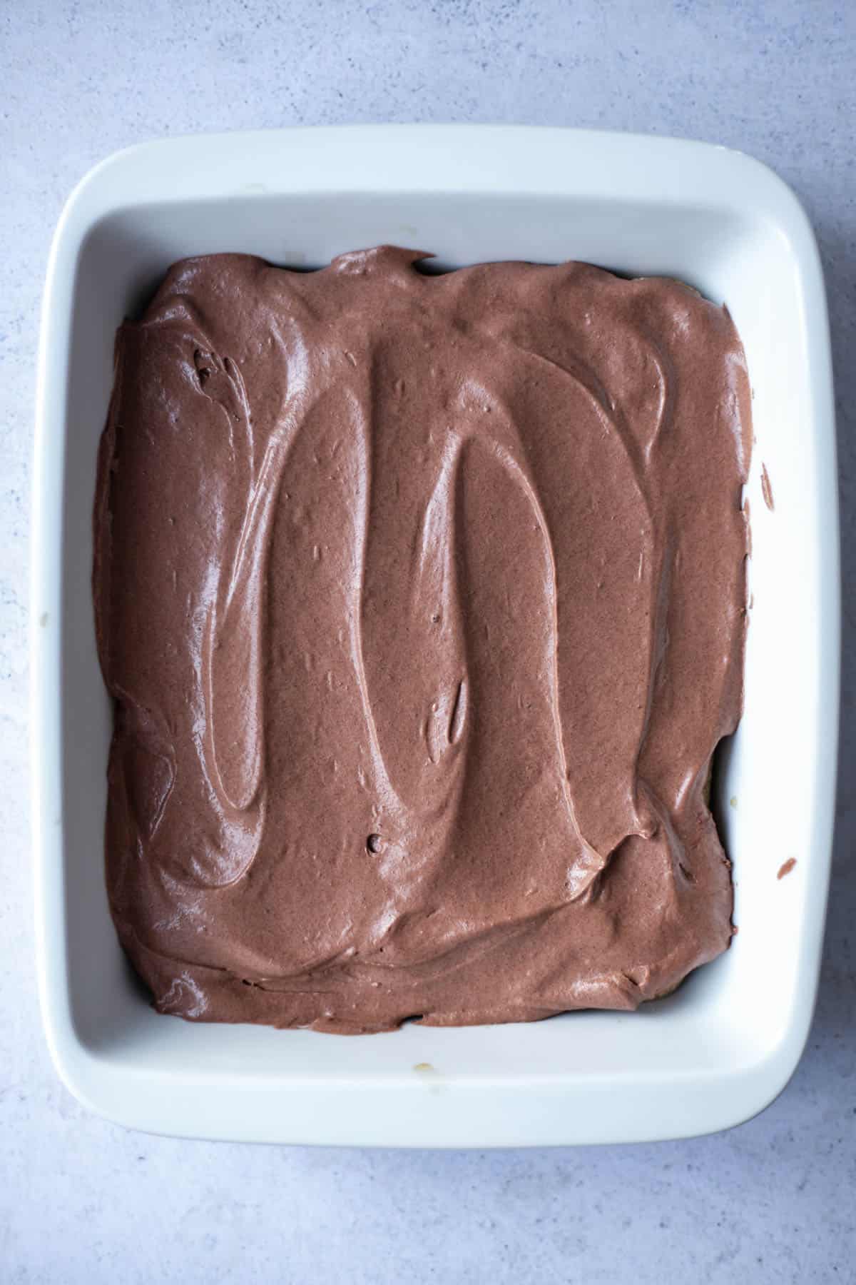 chocolate mascarpone spread over ladyfingers in a baking dish
