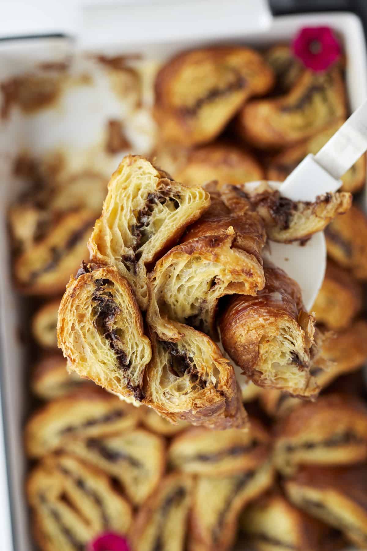 close up image of a spatula holding a serving of Nutella stuffed croissant french toast