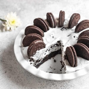 a whole no-bake Oreo pie in a white pie pan with a slice cut out