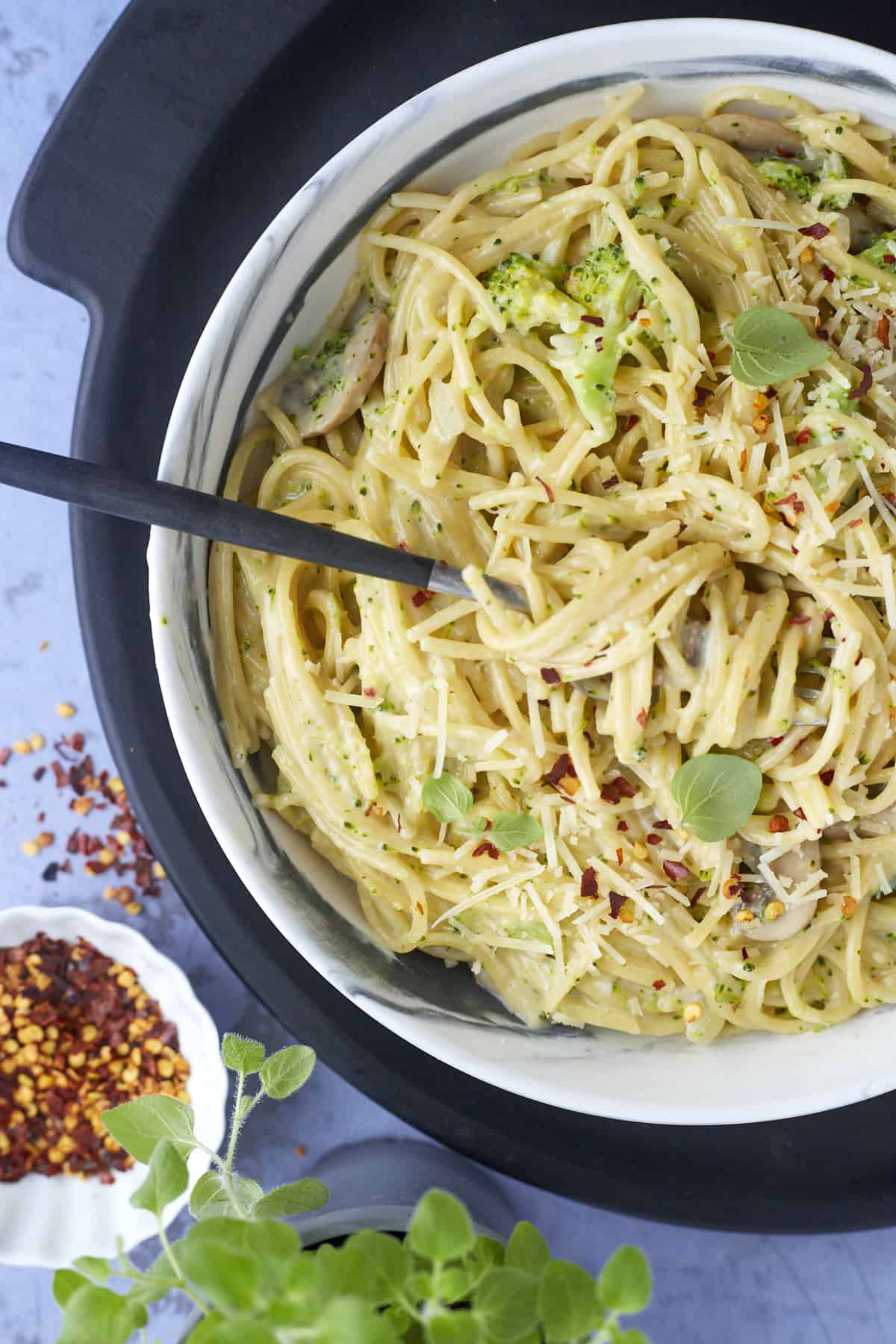 a fork twisted around a bite of pasta primavera in a bowl of pasta