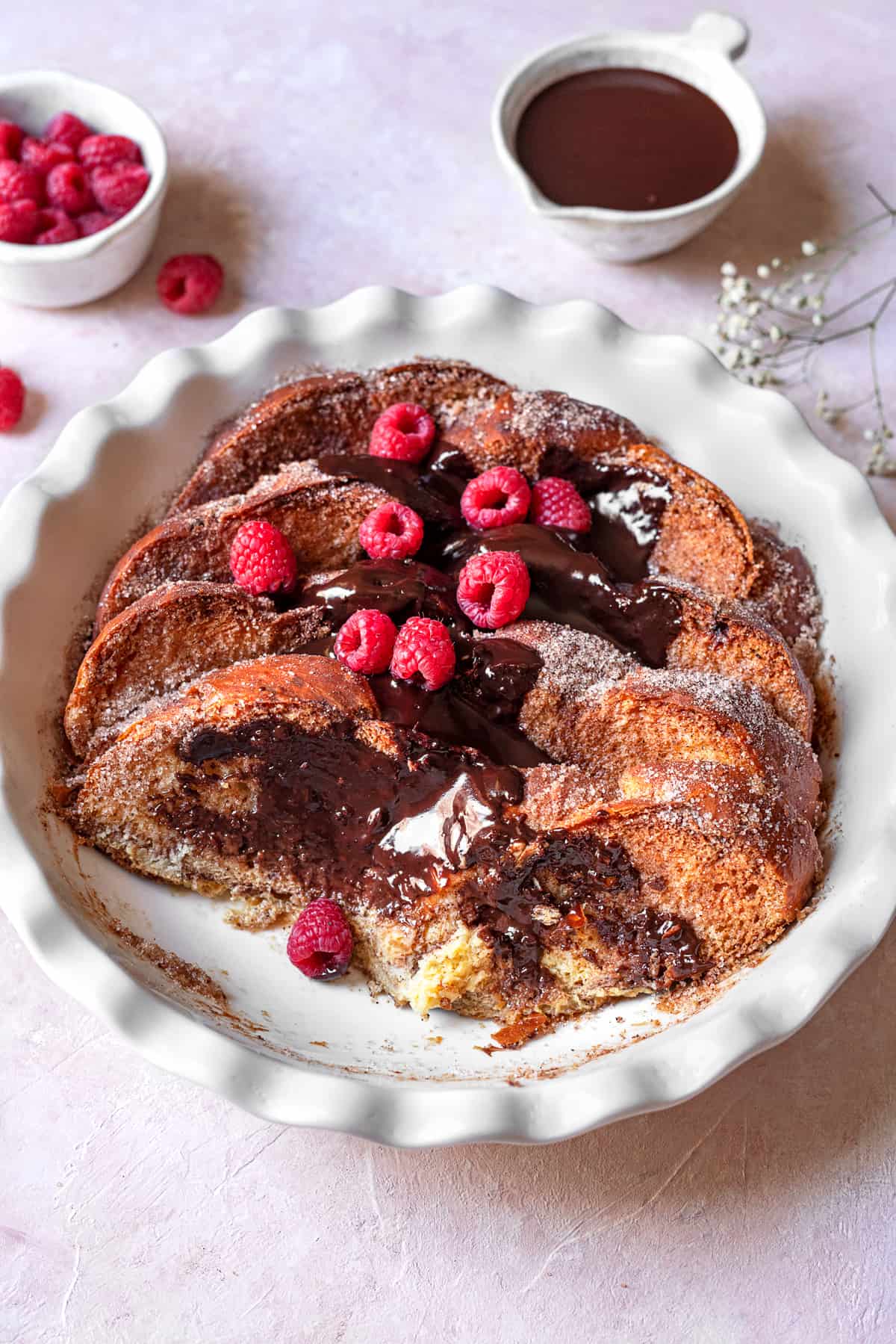 closeup of churro french toast with chocolate and raspberries