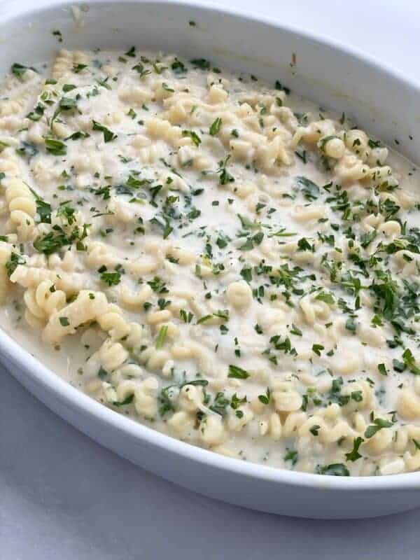 Parmesan Lemon Garlic Pasta in a white baking dish topped with fresh herbs