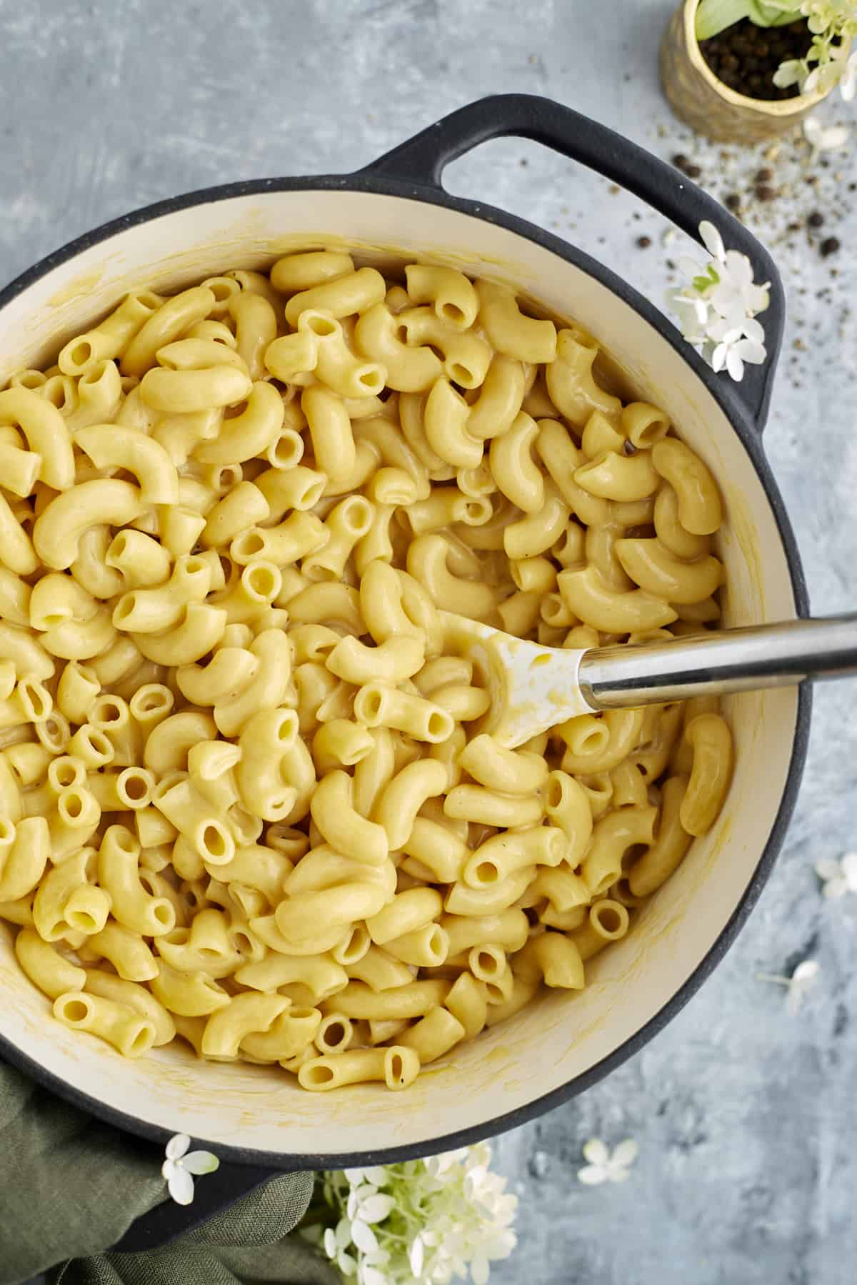 overhead image of one pot mac and cheese in a large pot being stirred with a spoon