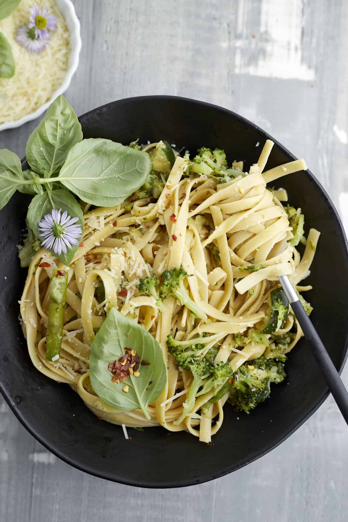 a black bowl of one pot veggie pasta with a fork twirling a bite