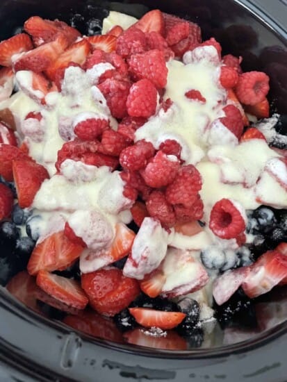 overhead image of summer berry cobbler in a slow cooker