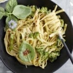 overhead image of a black bowl of pasta with veggies